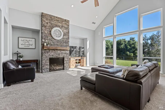 a living room with furniture a large window and a fireplace