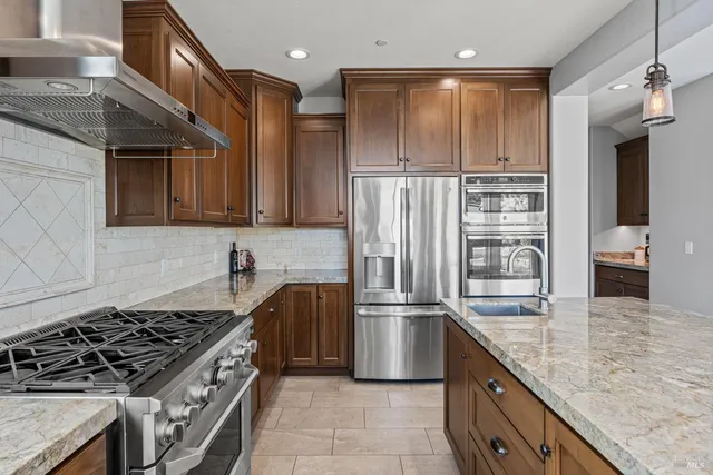 a kitchen with granite countertop a sink stove and refrigerator