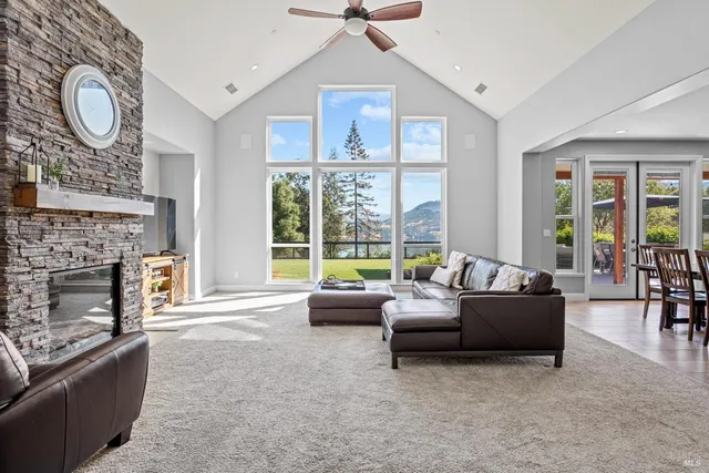 a living room with furniture a fireplace and a large window