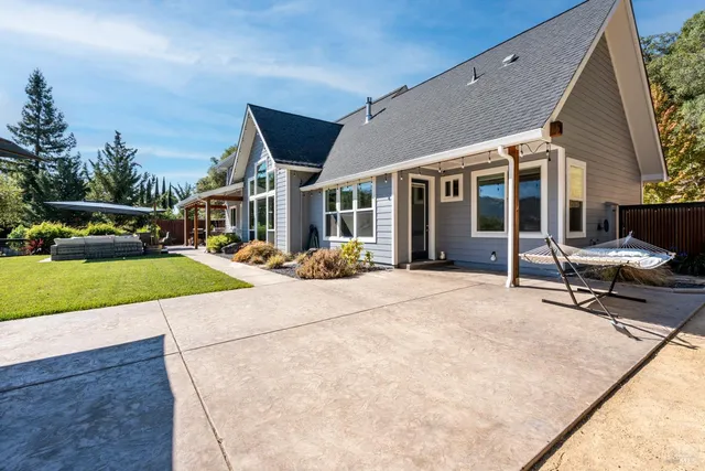 a view of a patio with couches table and chairs under an umbrella