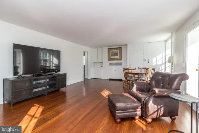 a kitchen with a sink dishwasher a stove and white cabinets with wooden floor
