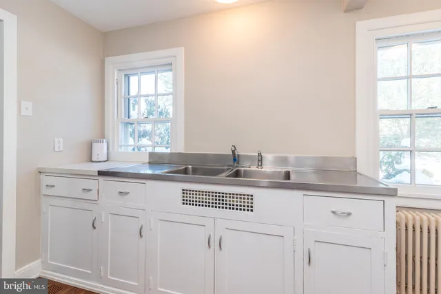 a front view of a house with a garden and trees