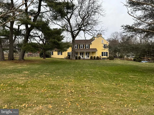 a front view of residential houses with yard and trees