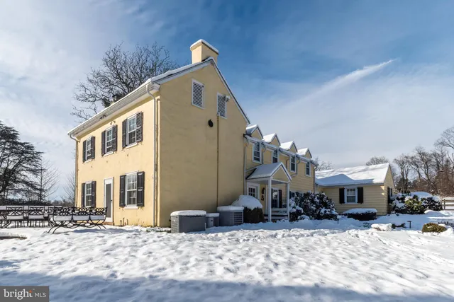 a view of a white house with a big yard and large trees