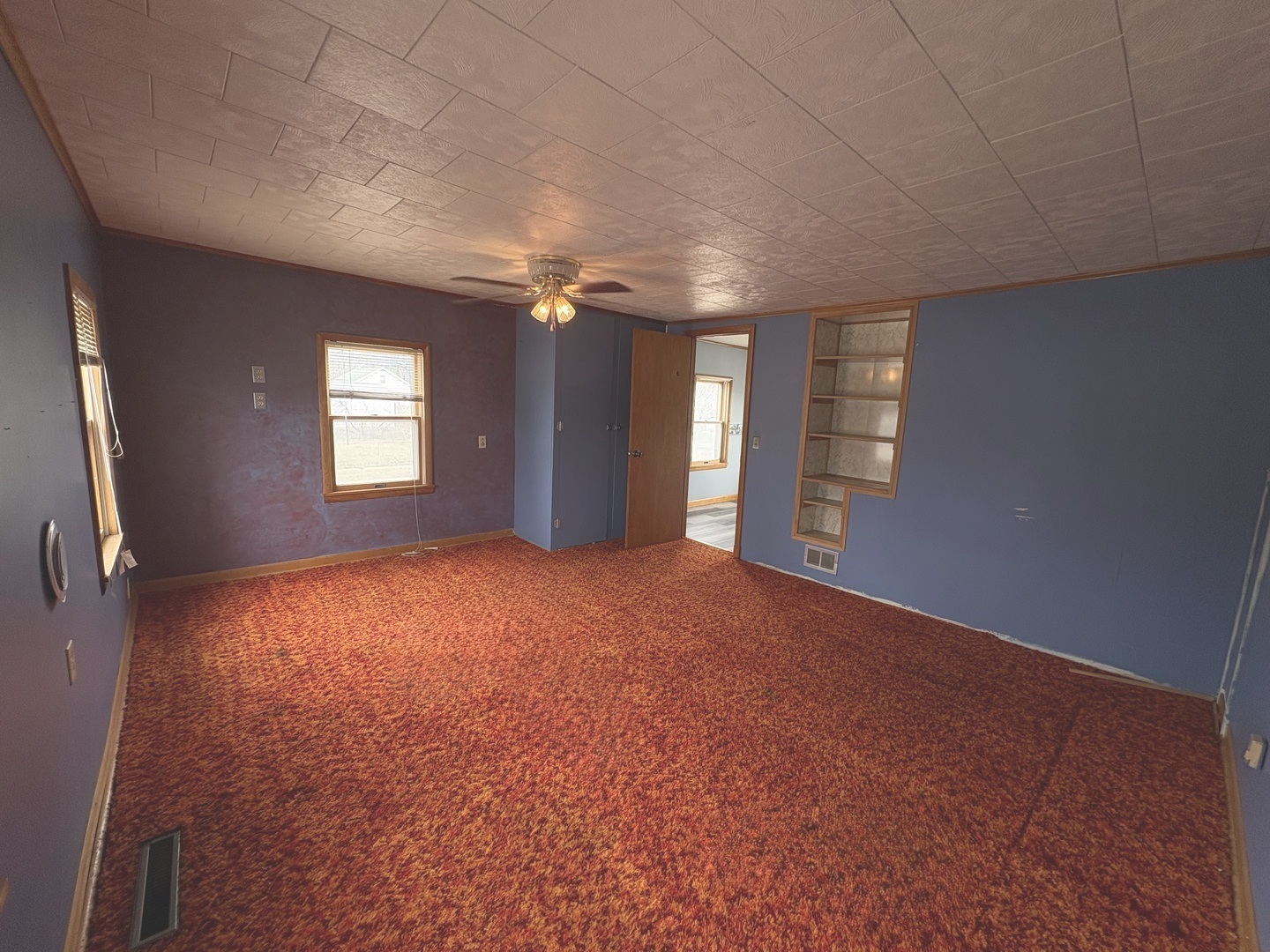 1022 1st Avenue Rochelle, IL 61068 - Photo 7 of 31 an empty room with windows and chandelier fan
