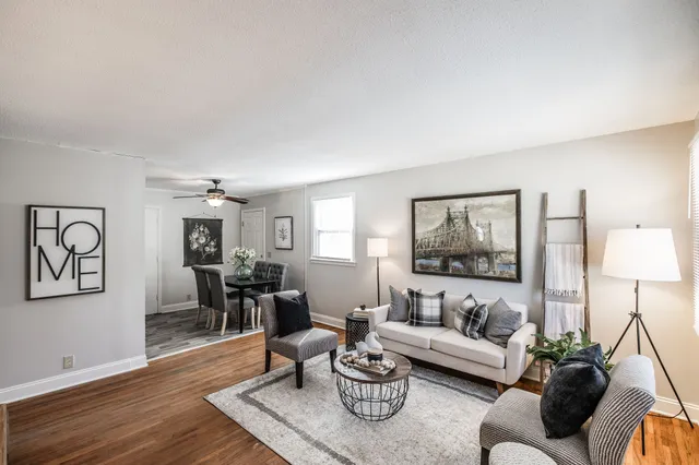 a living room with furniture a window and a clock