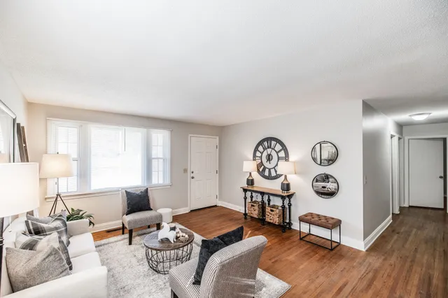 a living room with furniture kitchen view and a window