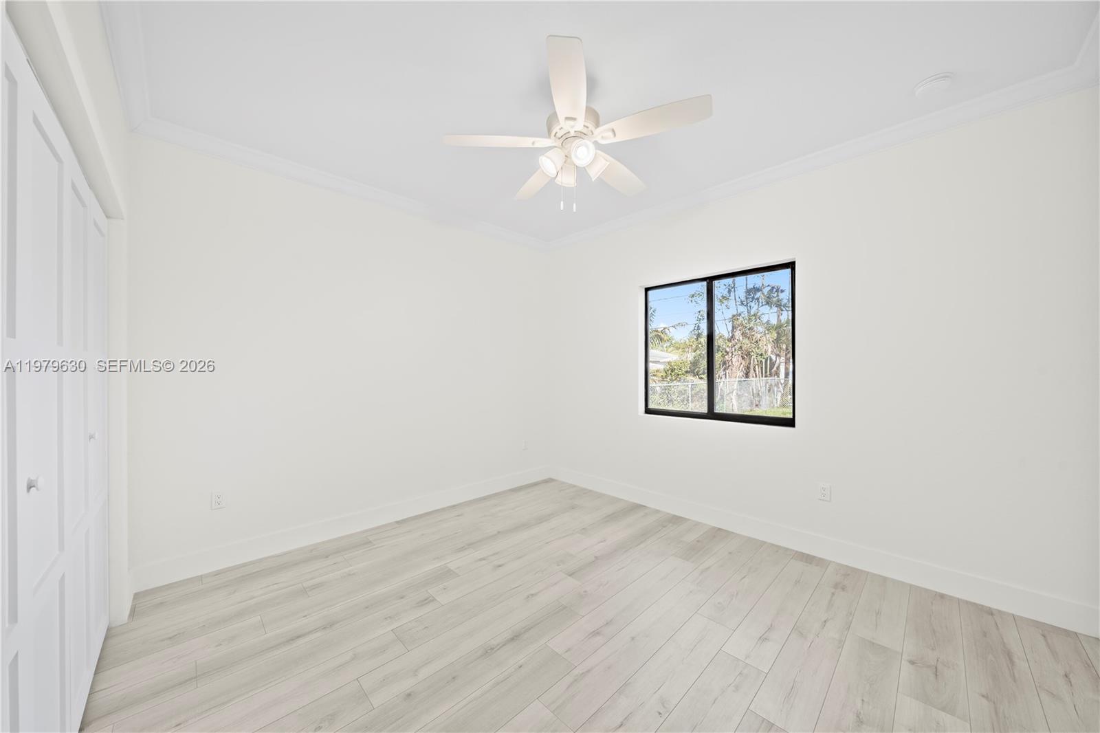 1735 Northwest 84th Street Miami, FL 33147 - Photo 19 of 26 an empty room with wooden floor closet and windows