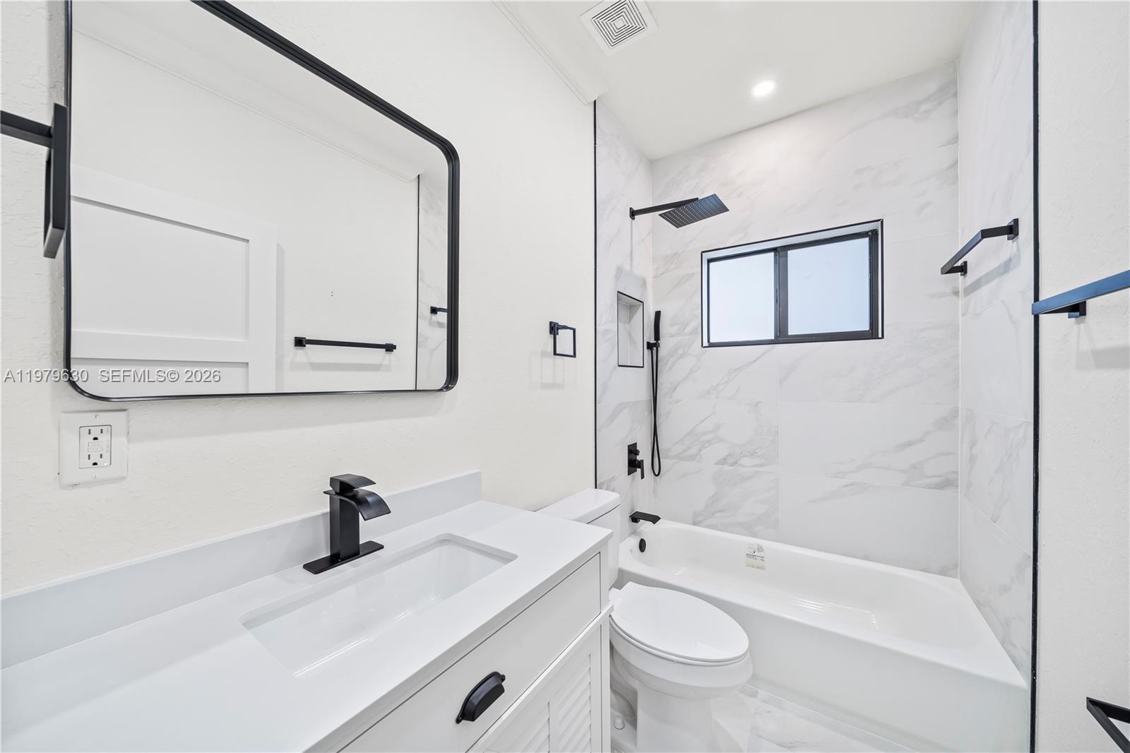1735 Northwest 84th Street Miami, FL 33147 - Photo 20 of 26 a bathroom with a granite countertop sink a toilet and a bathtub