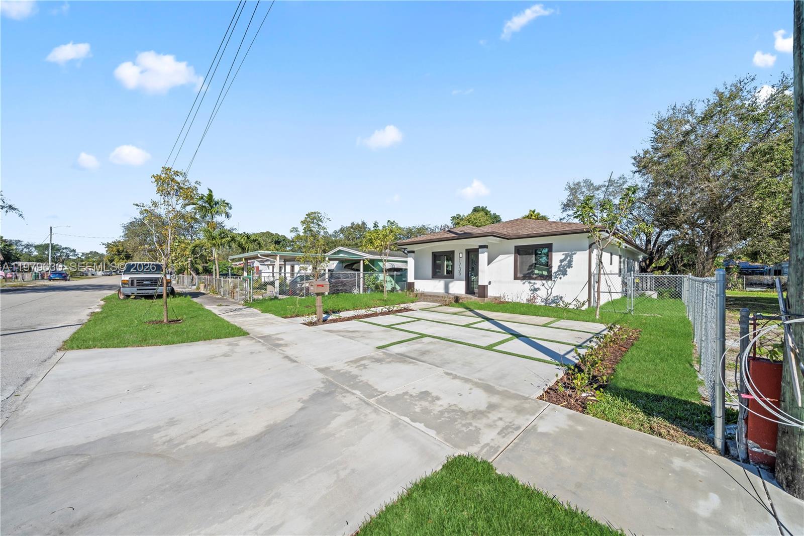 1735 Northwest 84th Street Miami, FL 33147 - Photo 5 of 26 a view of a white house with a big yard and potted plants