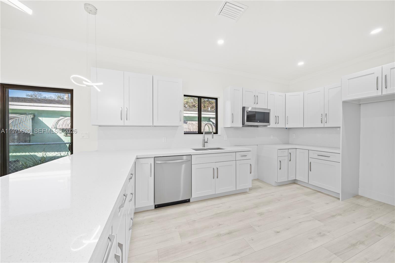 1735 Northwest 84th Street Miami, FL 33147 - Photo 8 of 26 a kitchen with granite countertop white cabinets and white appliances