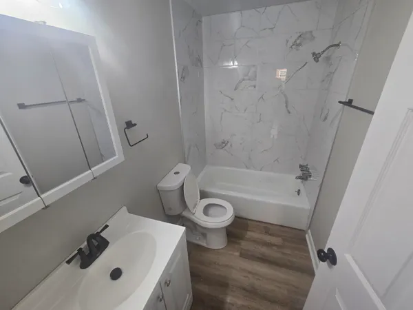 a bathroom with a sink a toilet and shower