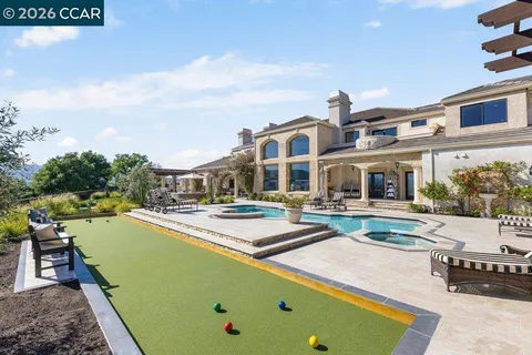 a view of a swimming pool with a yard and mountain view