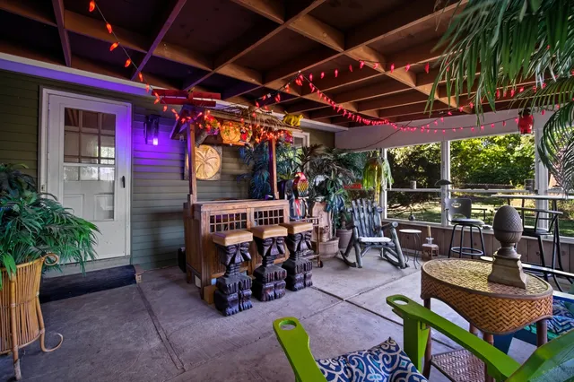 a view of a chair and table in backyard of the house