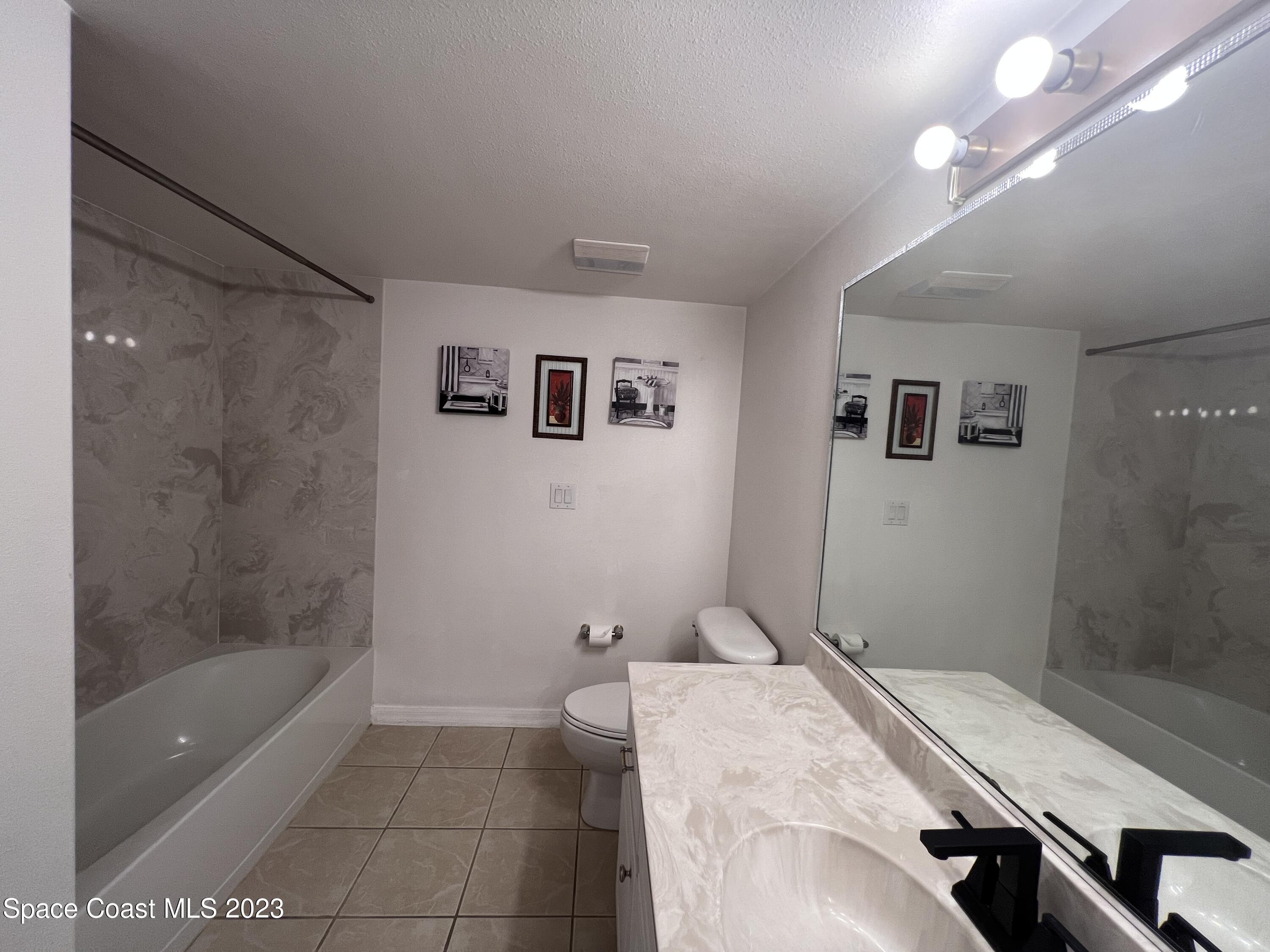 800 Del Rio Way, Unit 402 Merritt Island, FL 32953 - Photo 12 of 24 a bathroom with a granite countertop sink a toilet and shower