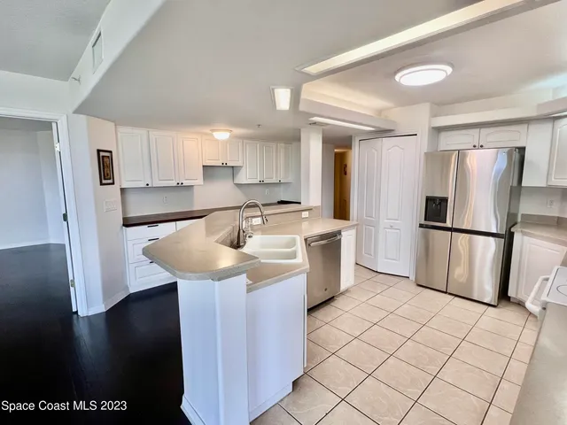 a kitchen with a sink a refrigerator a microwave and cabinets