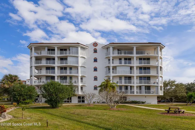 a front view of building with yard and swimming pool
