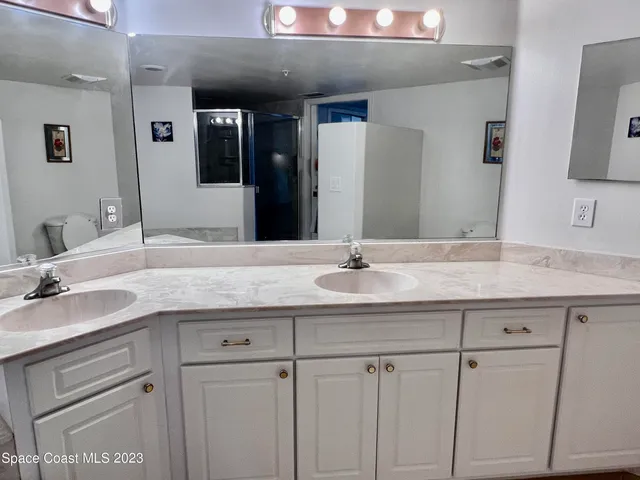 a bathroom with a granite countertop sink and white