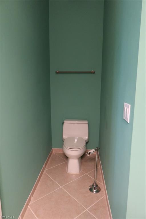 7168 Lemuria Circle, Unit 1701 Naples, FL 34109 - Photo 30 of 39 Enclosed water closet featuring a standard toilet, tiled flooring, and a wall-mounted towel bar