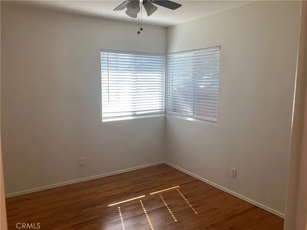 a view of a room with wooden floor and windows