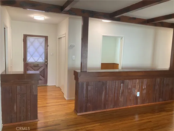 a hallway with wooden floor closet and bathroom