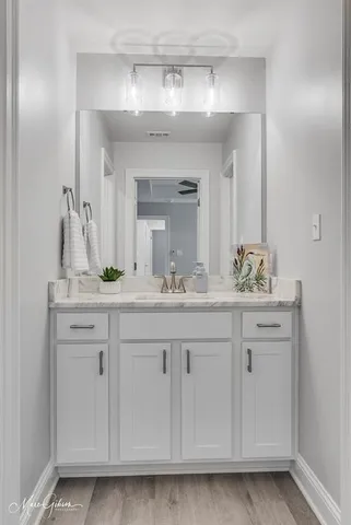 a bathroom with a sink vanity and mirror