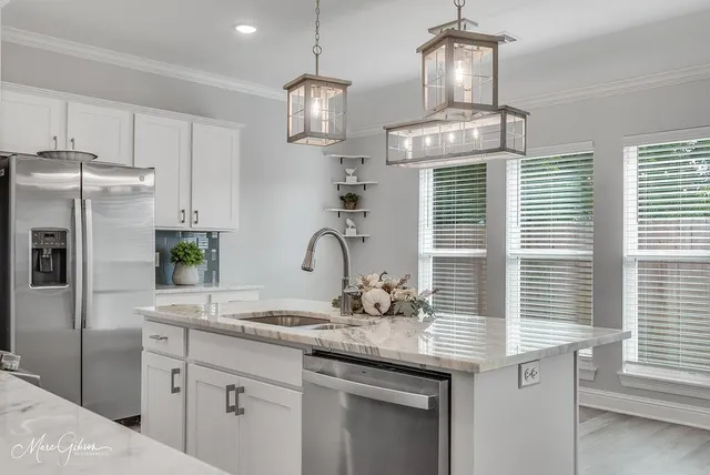 a kitchen with granite countertop stainless steel appliances a sink and cabinets