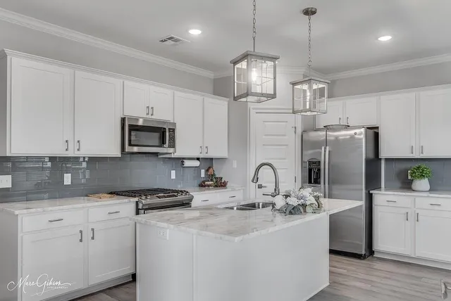 a kitchen with stainless steel appliances kitchen island granite countertop a sink a stove and cabinets