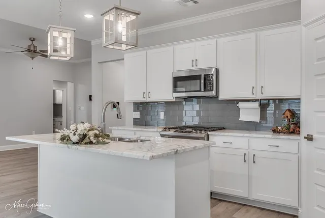 a kitchen with stainless steel appliances granite countertop a sink a stove and cabinets