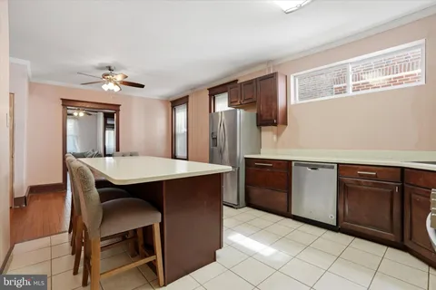 a kitchen with stainless steel appliances a table and chairs in it