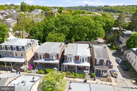 an aerial view of a residential apartment building with a yard and parking spaces