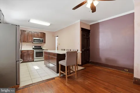 a kitchen with stainless steel appliances kitchen island granite countertop a refrigerator and a stove top oven