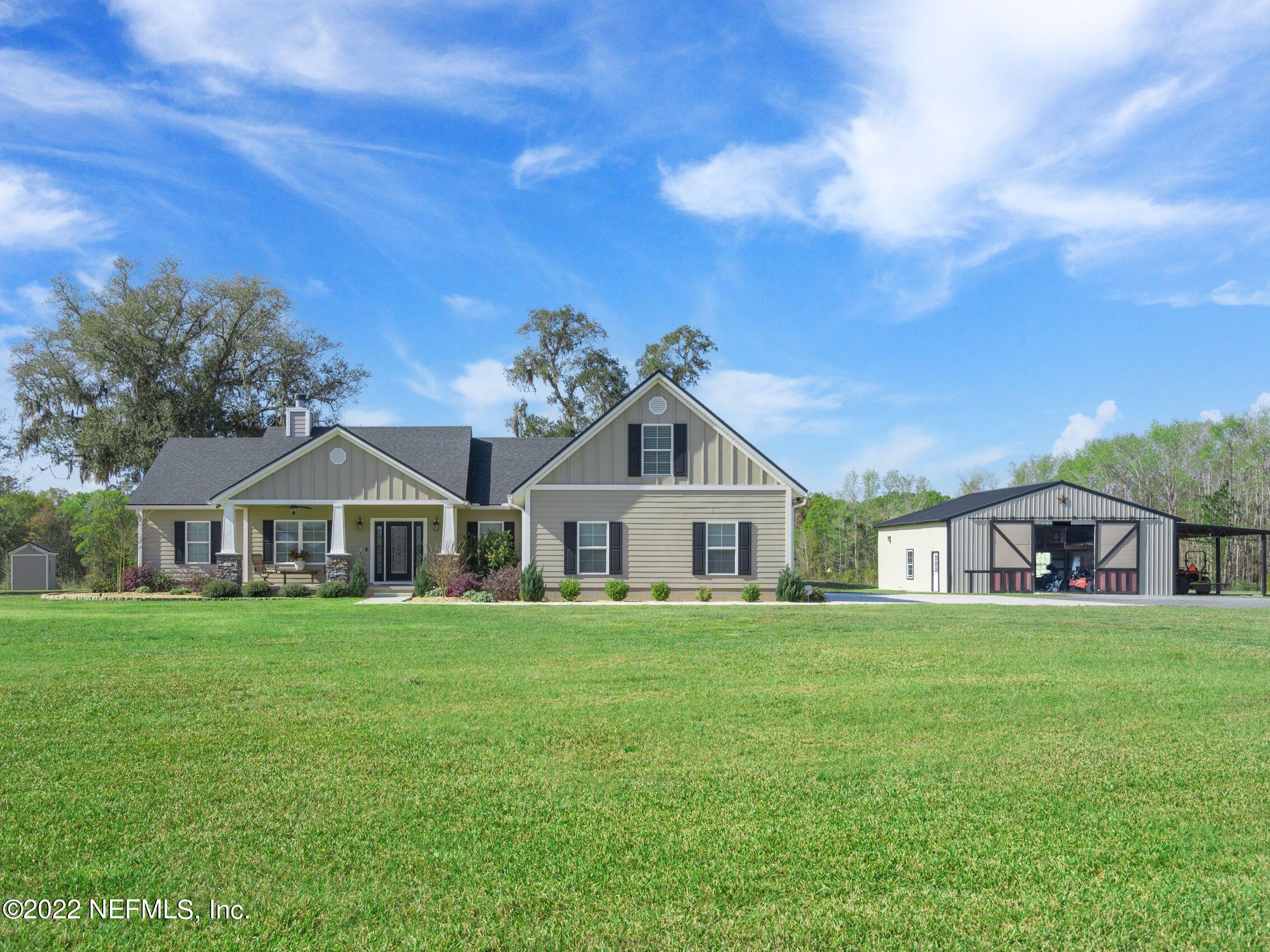 54476 Wildlife Way Callahan, FL 32011 - Photo 1 of 35 a white house with a big yard and large trees