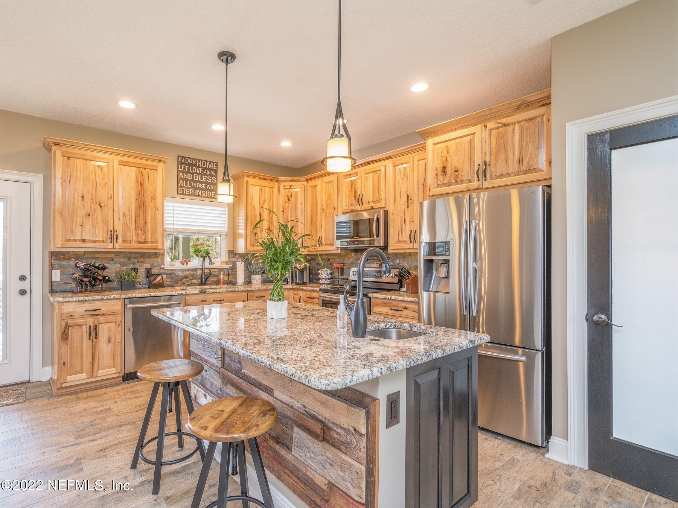 54476 Wildlife Way Callahan, FL 32011 - Photo 11 of 35 a kitchen with stainless steel appliances granite countertop sink stove and refrigerator