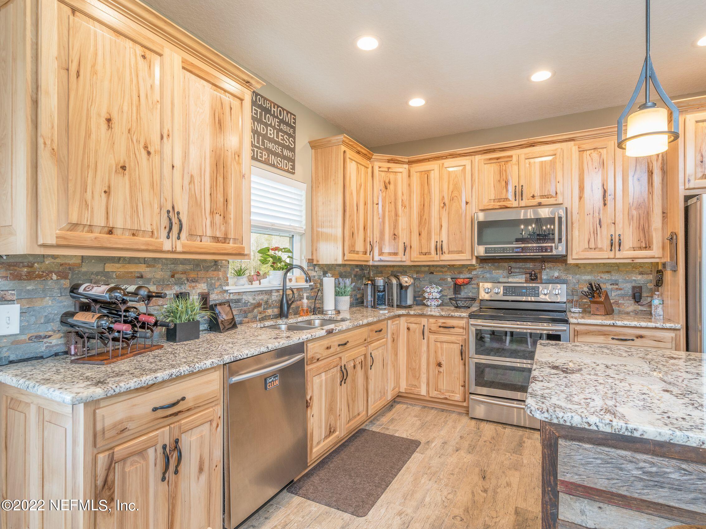 54476 Wildlife Way Callahan, FL 32011 - Photo 12 of 35 a kitchen with a stove a sink and a microwave