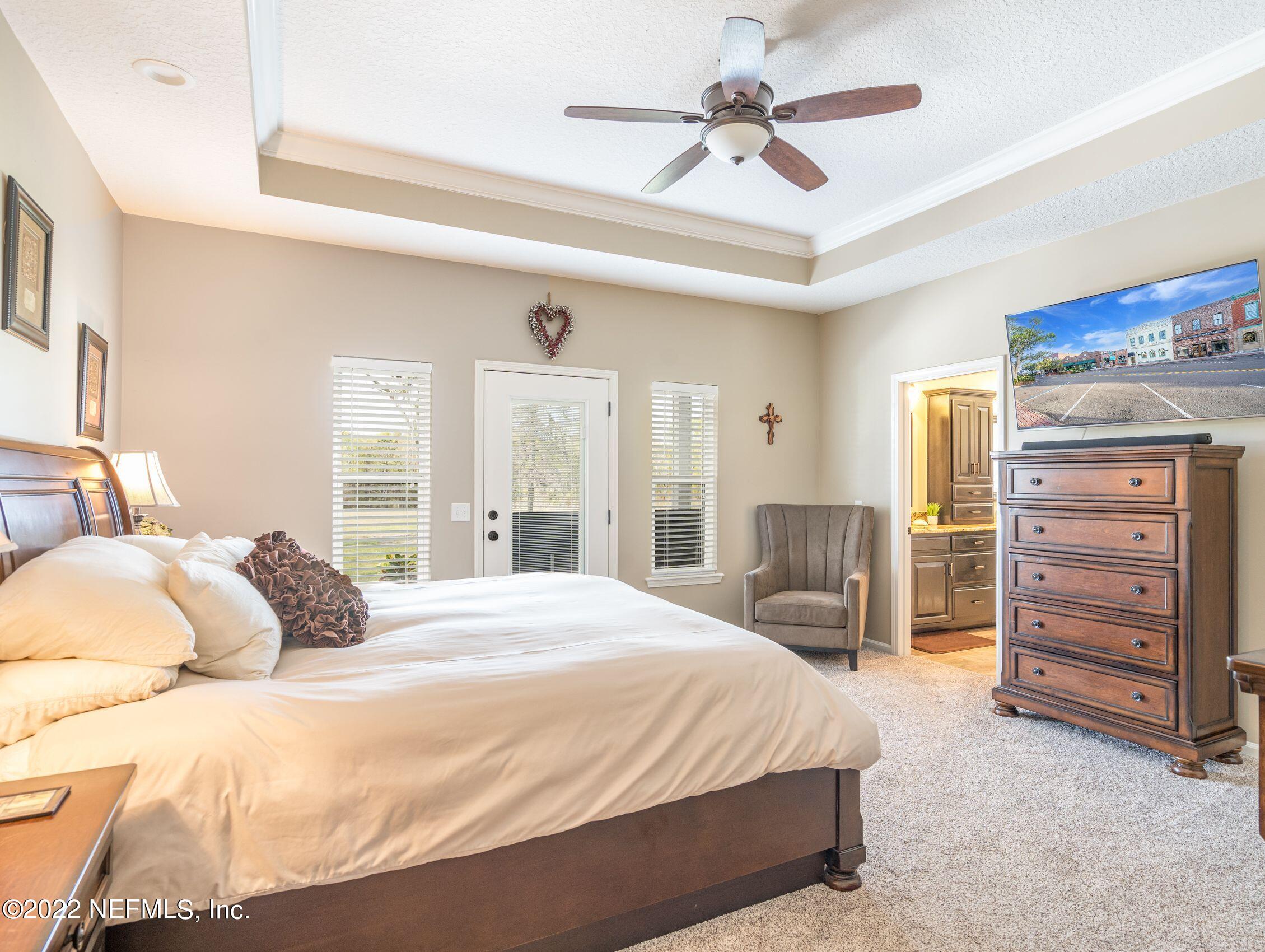 54476 Wildlife Way Callahan, FL 32011 - Photo 15 of 35 a bedroom with a bed a dresser and a chandelier