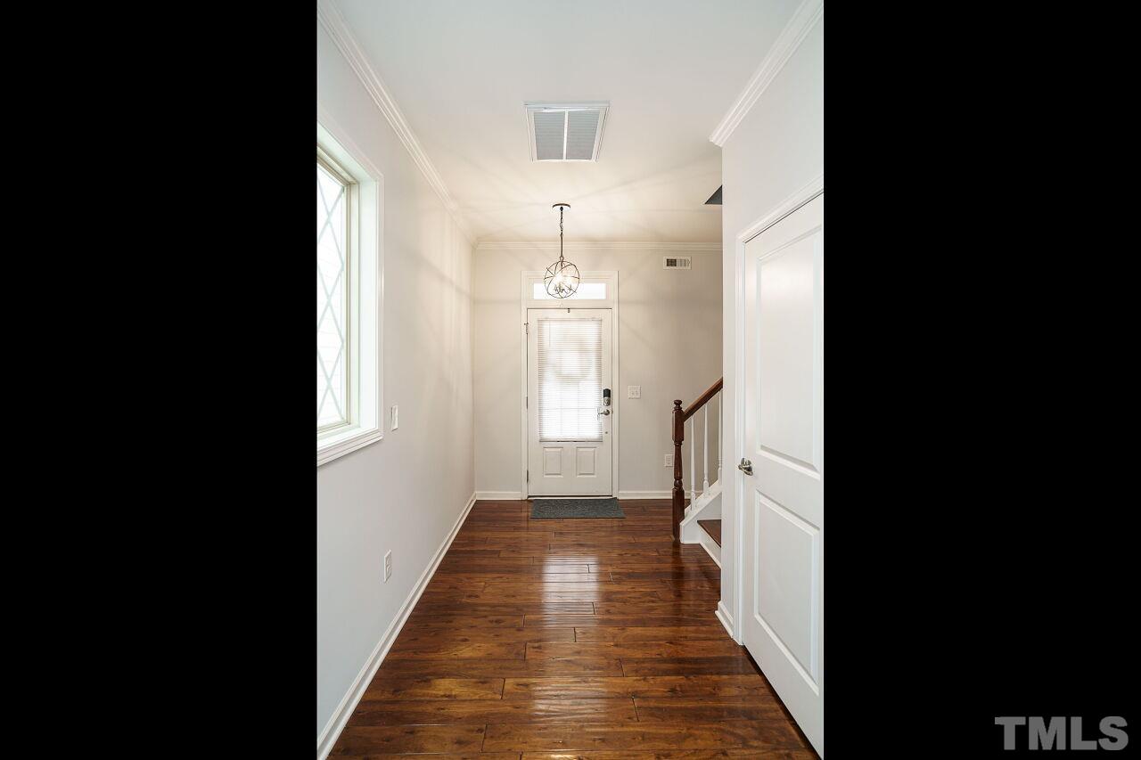 1308 Rodessa Run Raleigh, NC 27607 - Photo 5 of 31 a view of a hallway with wooden floor and staircase