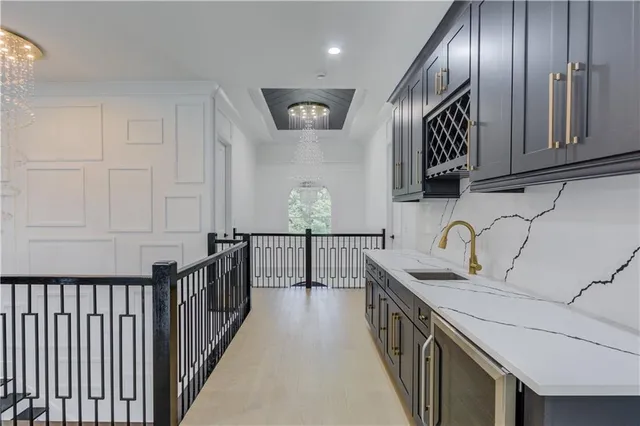 a kitchen with granite countertop stainless steel appliances a sink dishwasher a refrigerator and wooden cabinets