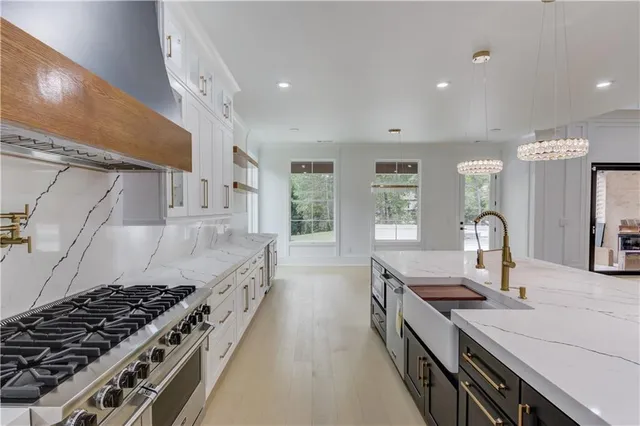 a kitchen with stove a sink and cabinets
