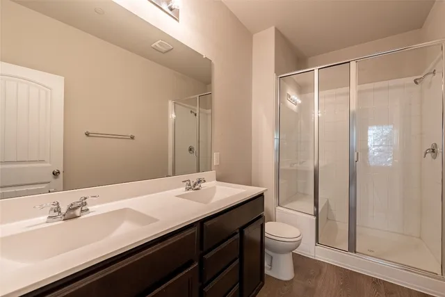a bathroom with a double vanity sink toilet and shower