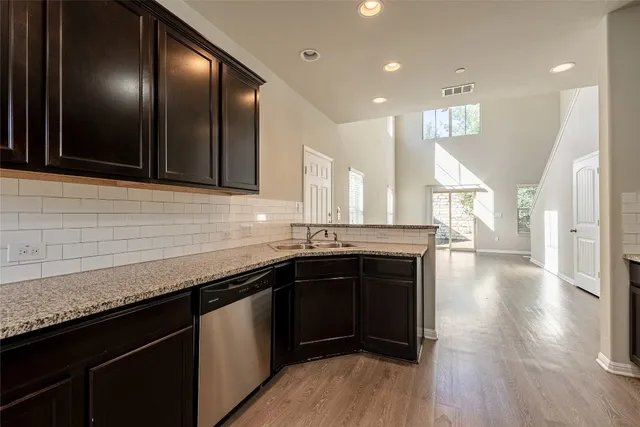 a kitchen with stainless steel appliances granite countertop a sink a stove and cabinets