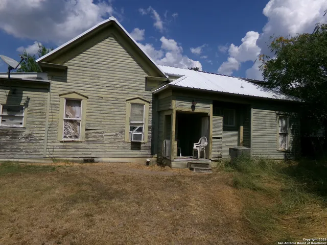 a view of house with backyard and sitting area