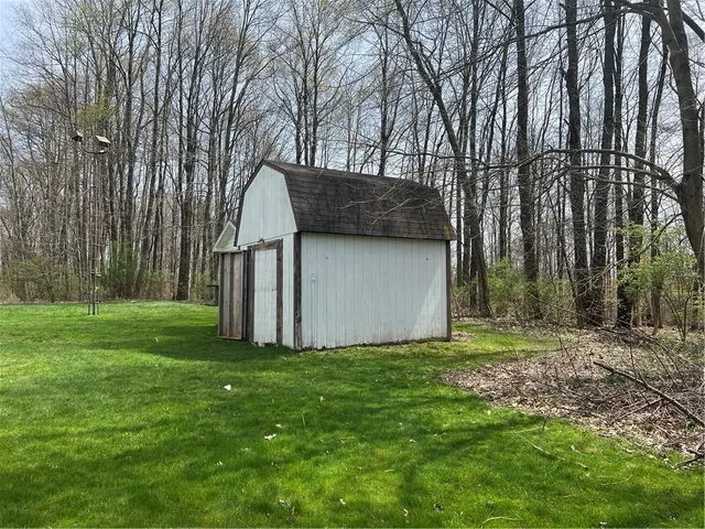 a view of a back yard with an tree and a wooden fence