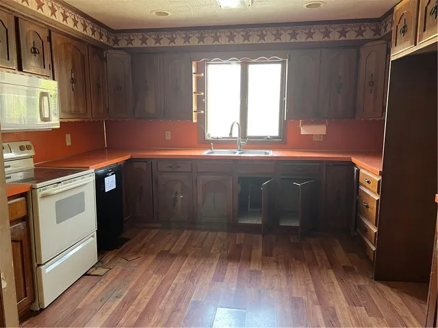 a kitchen with a sink and wooden floor