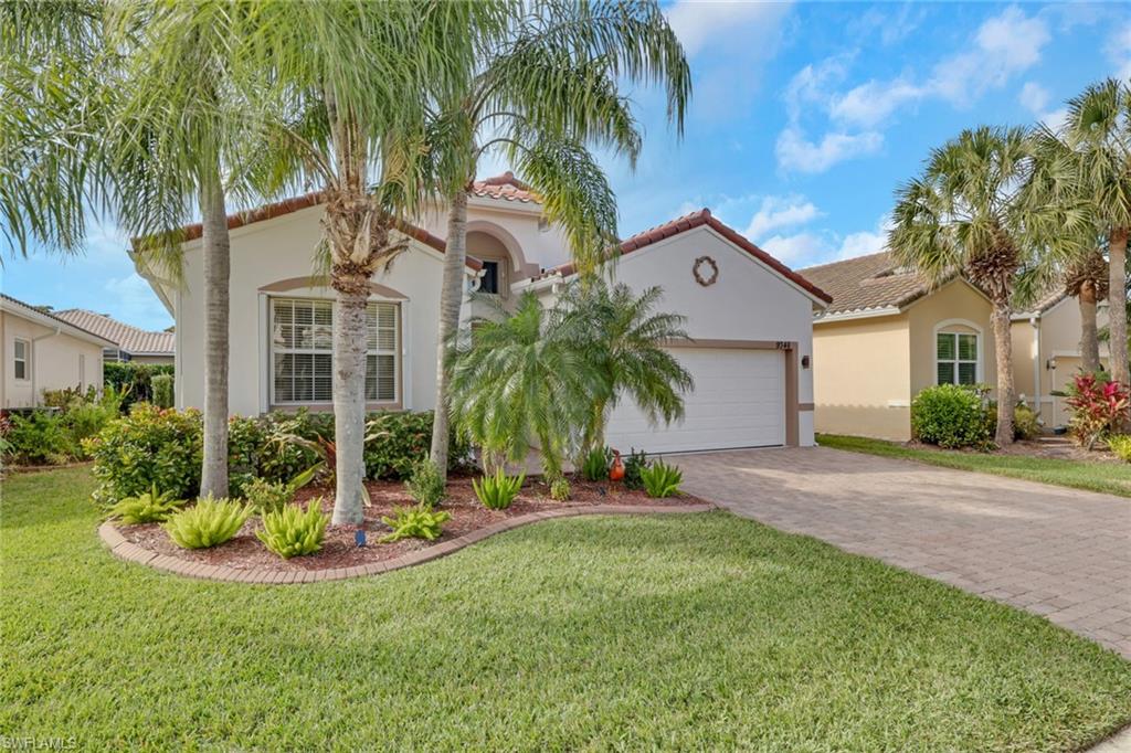 a front view of a house with a yard and palm trees