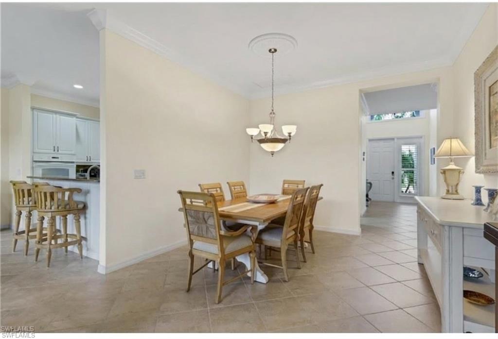 9348 Sun River Way Estero, FL 33928 - Photo 12 of 50 Dining room featuring crown molding, light tile patterned floors, and hanging lights