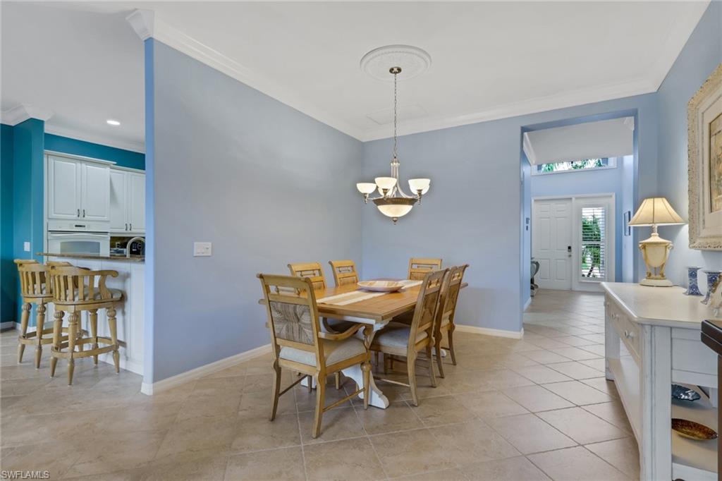 9348 Sun River Way Estero, FL 33928 - Photo 13 of 50 Dining space featuring ornamental molding, light tile patterned floors, and a chandelier