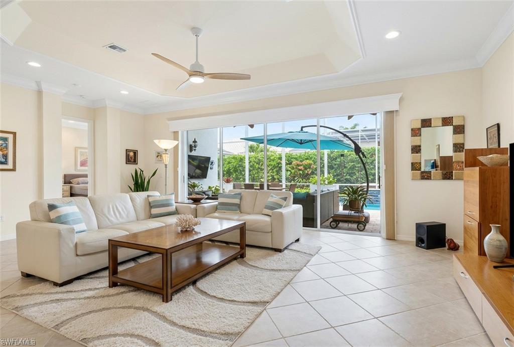 9348 Sun River Way Estero, FL 33928 - Photo 18 of 50 Living area featuring a sunroom, a ceiling fan, crown molding, recessed lighting, and a tray ceiling