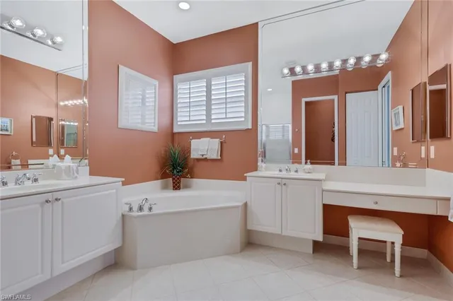 a bathroom with a sink double vanity mirror and a bathtub