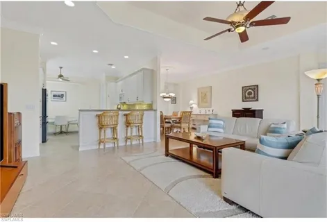 a living room with furniture kitchen view and a flat screen tv